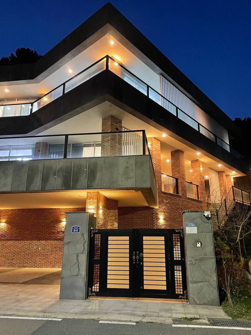 Oqshomda yorug'likda porlayotgan villa fasadi